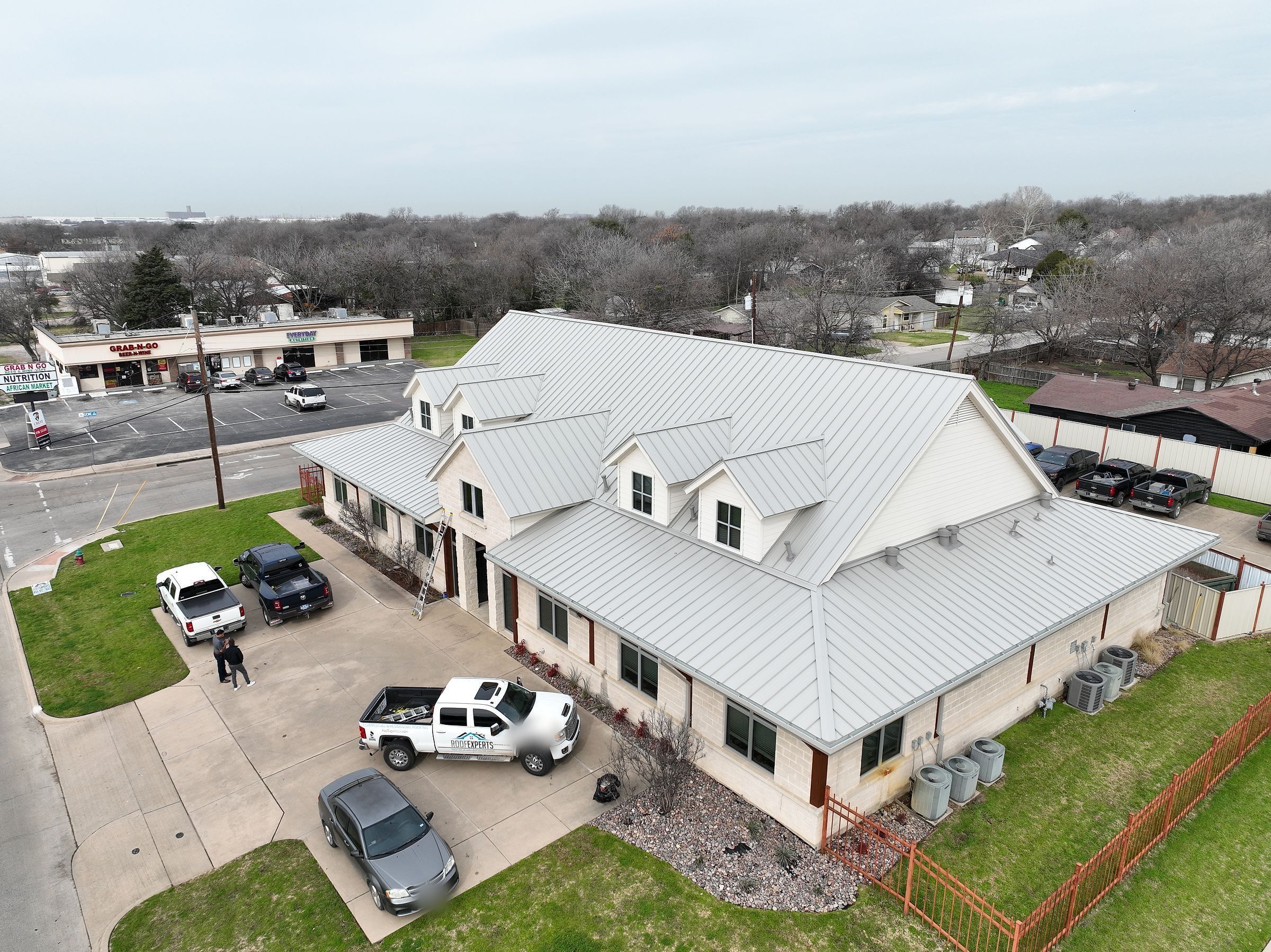 Finished standing-seam metal roof on a commercial office building, seen by drone