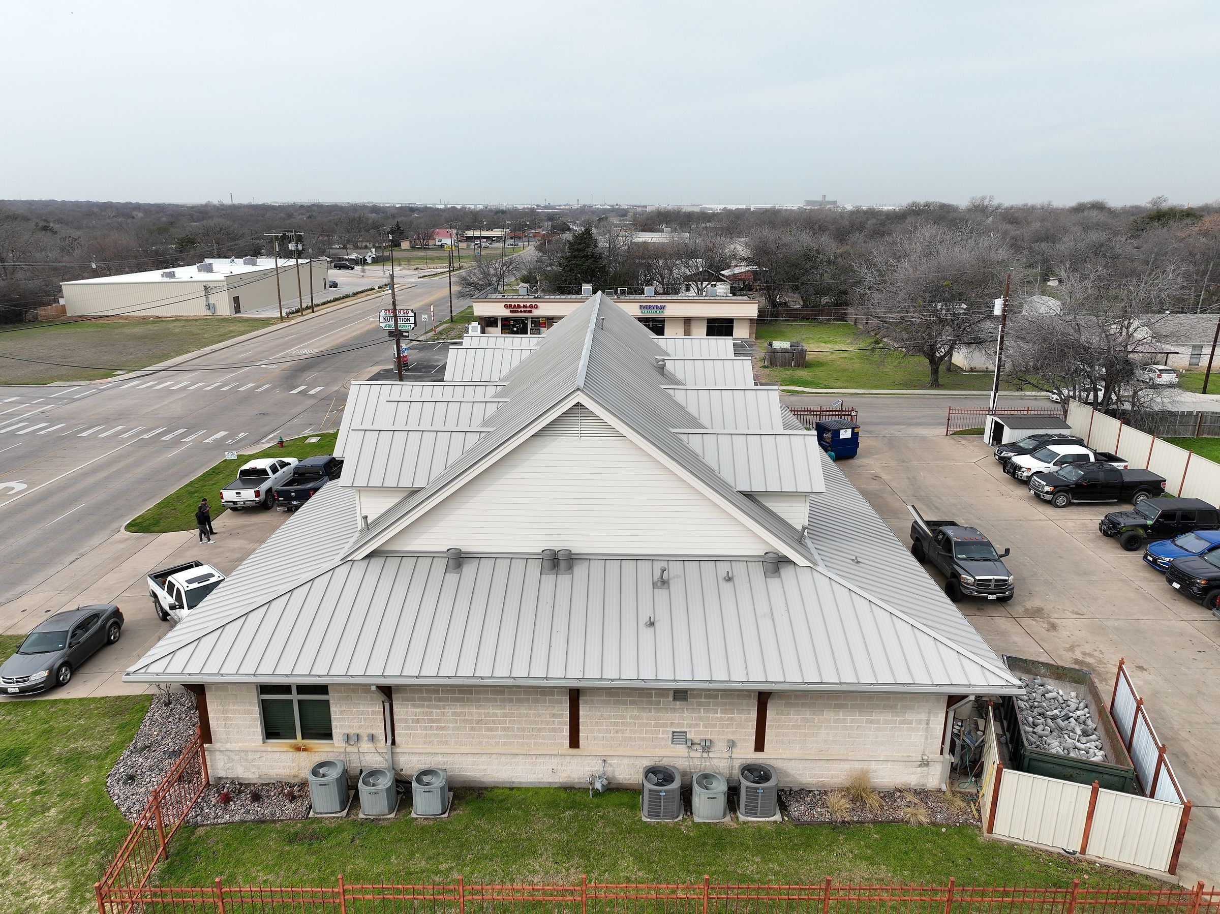 Finished silver standing-seam metal roof on a commercial office building, aerial view