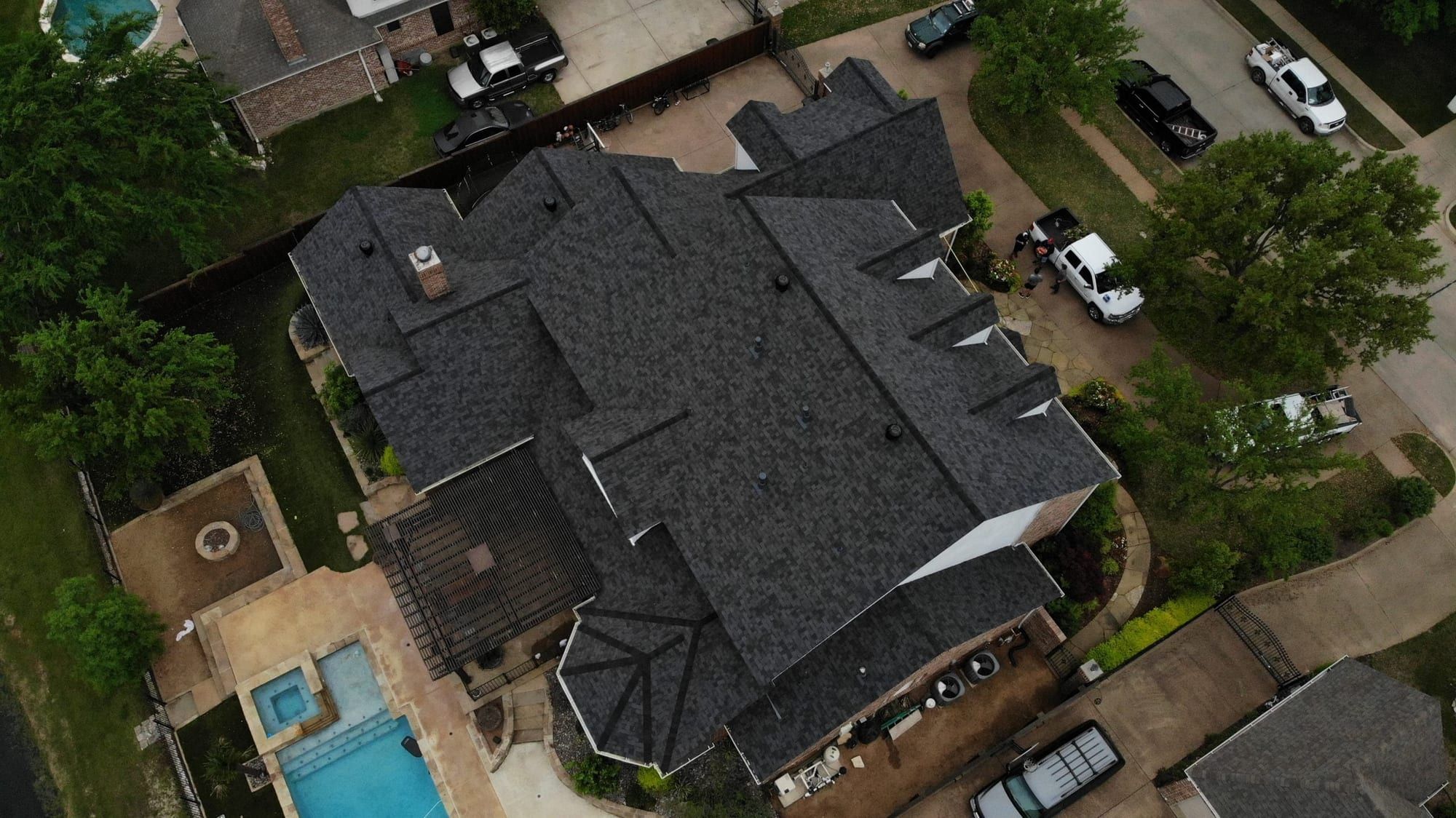 Large home with a new charcoal architectural shingle roof, seen from above