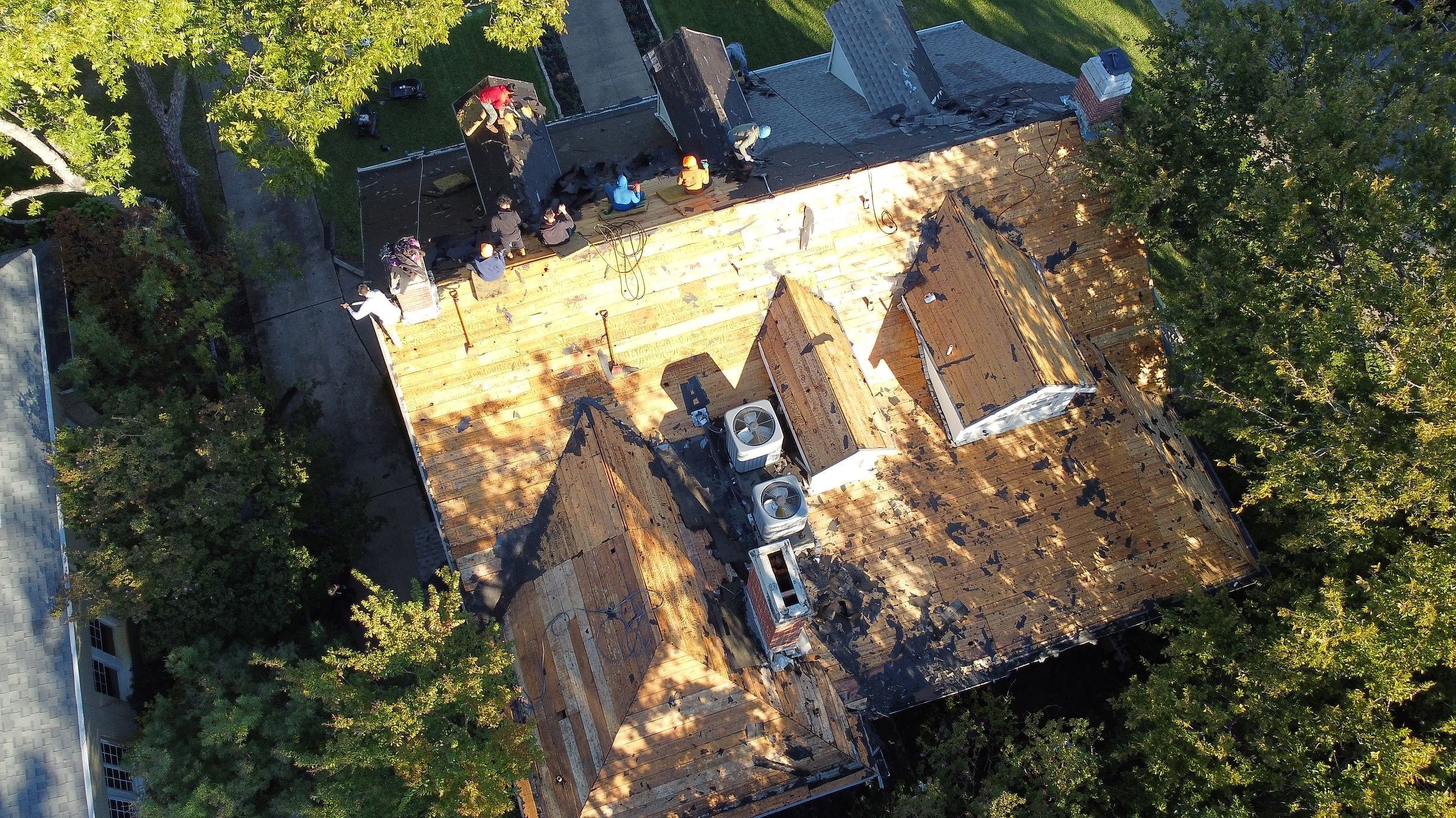 Roofers working on an exposed roof deck around dormers