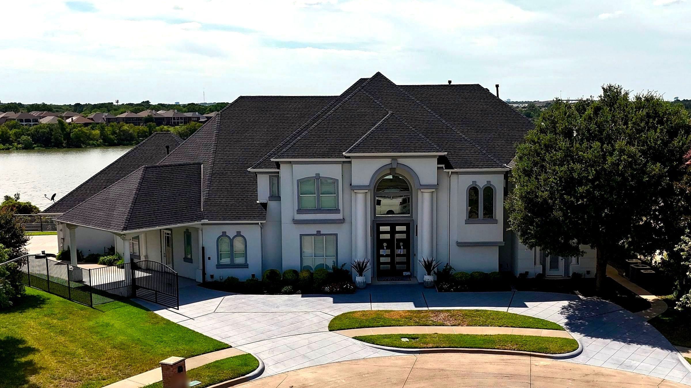 White two-story home on Lake Arlington with a new charcoal shingle roof