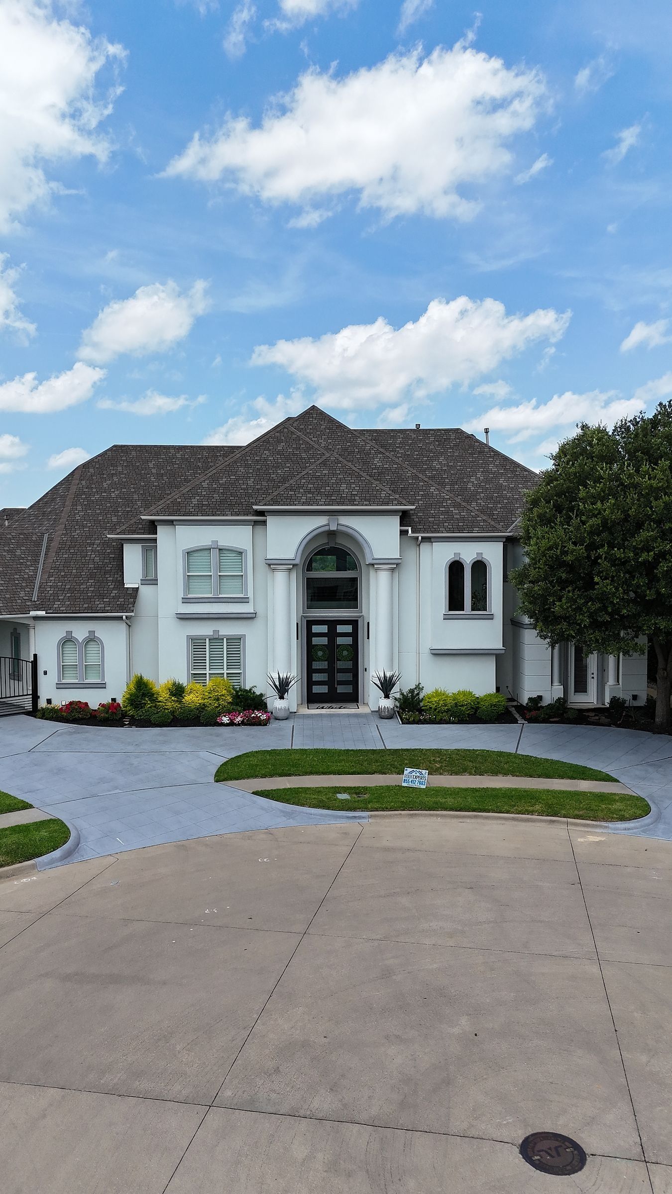 Front of a white two-story home before its roof replacement
