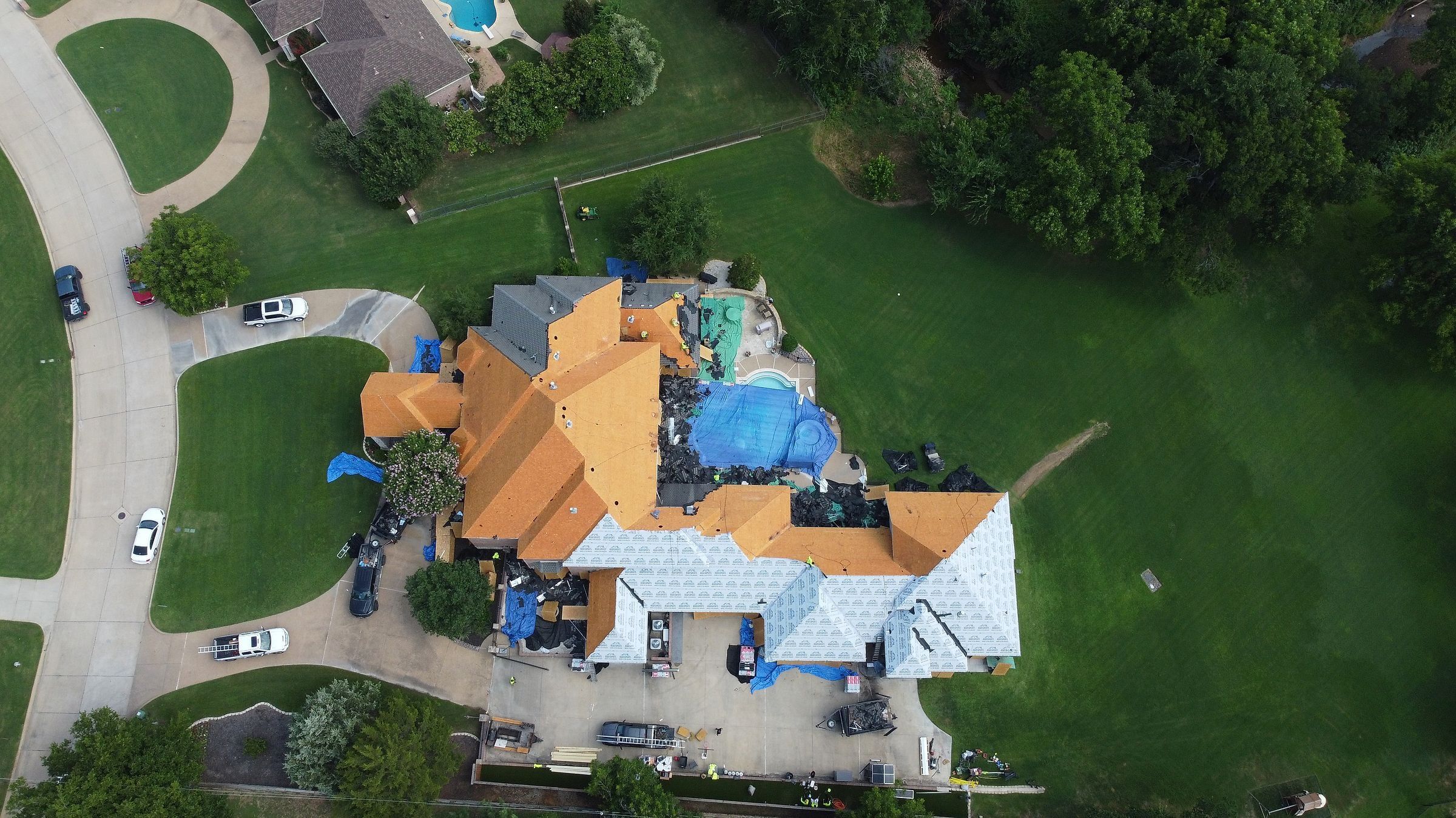 Large home in Arlington, TX half decked and half dried in during a roof replacement, pool covered
