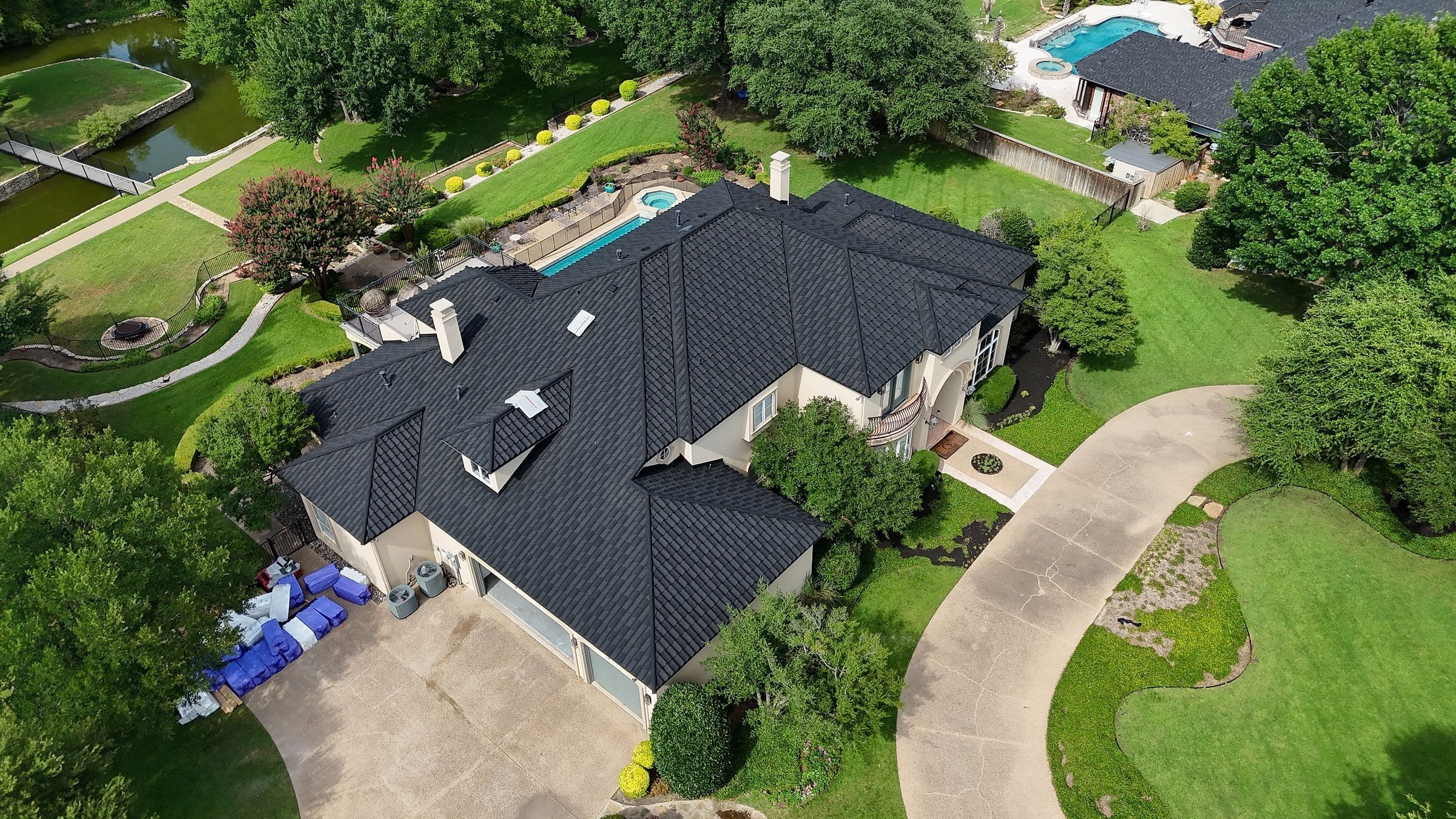 Black stone-coated steel roof on a large stucco home