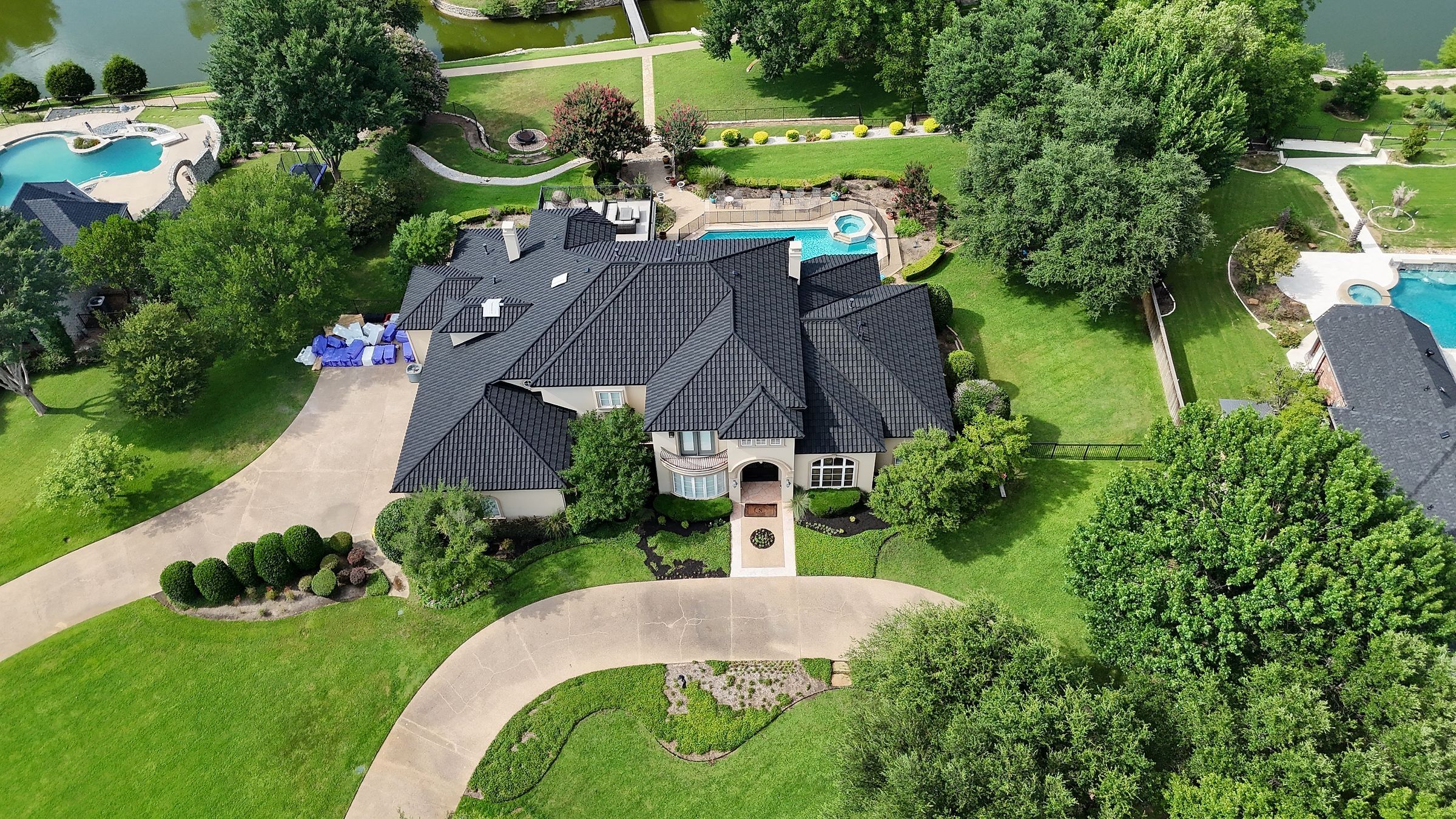 Stone-coated steel roof on a Mansfield, TX home with a pool and curved driveway