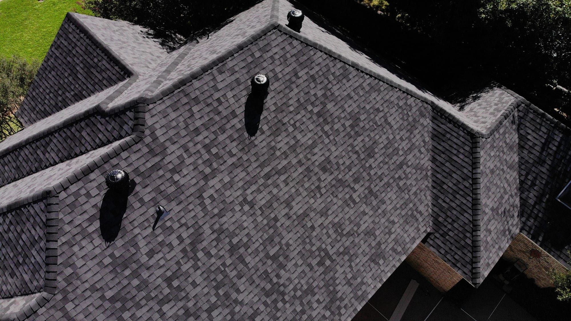 Close view of newly installed dark architectural shingles and roof vents