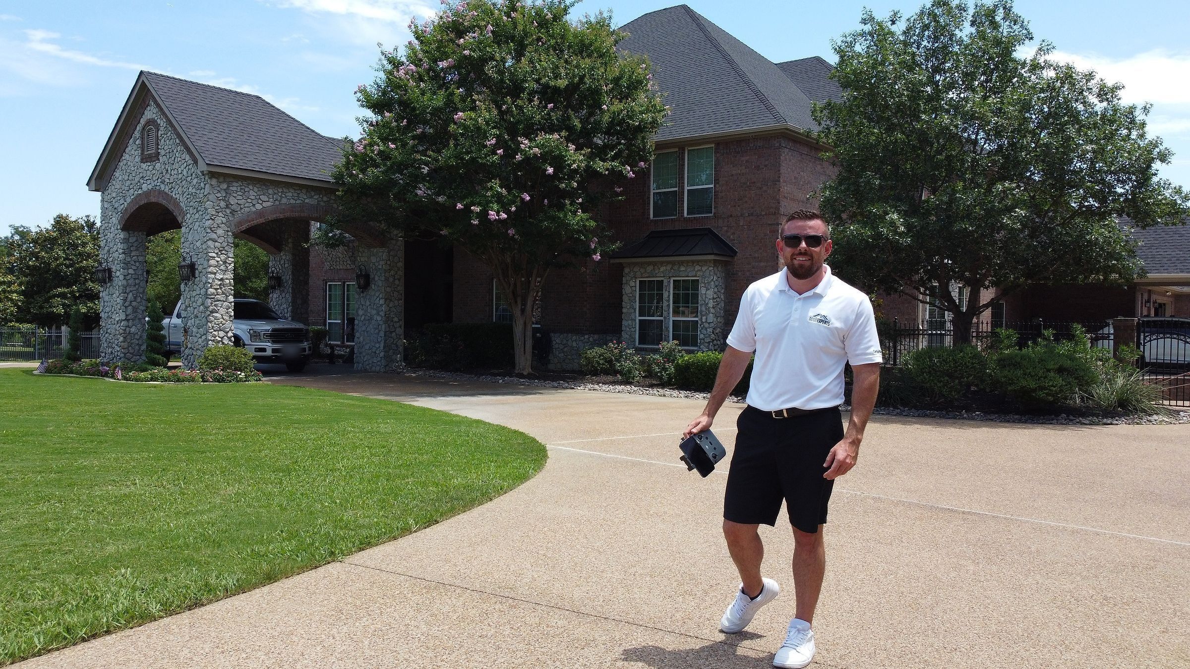 Roof Experts owner in the driveway of a finished roof replacement