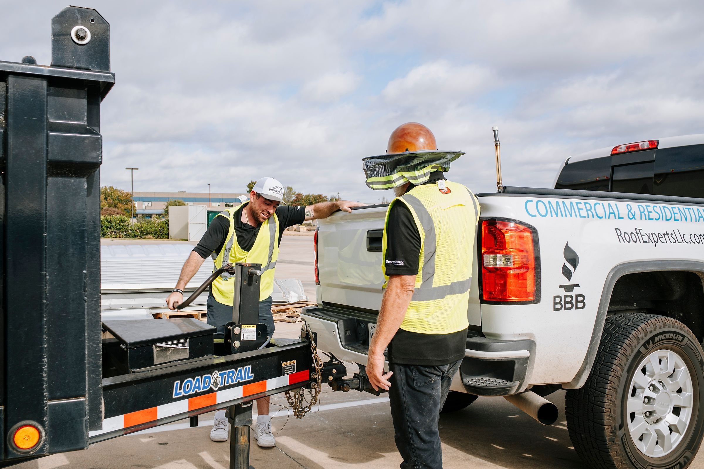 Roof Experts owner and crew foreman at the work truck and trailer