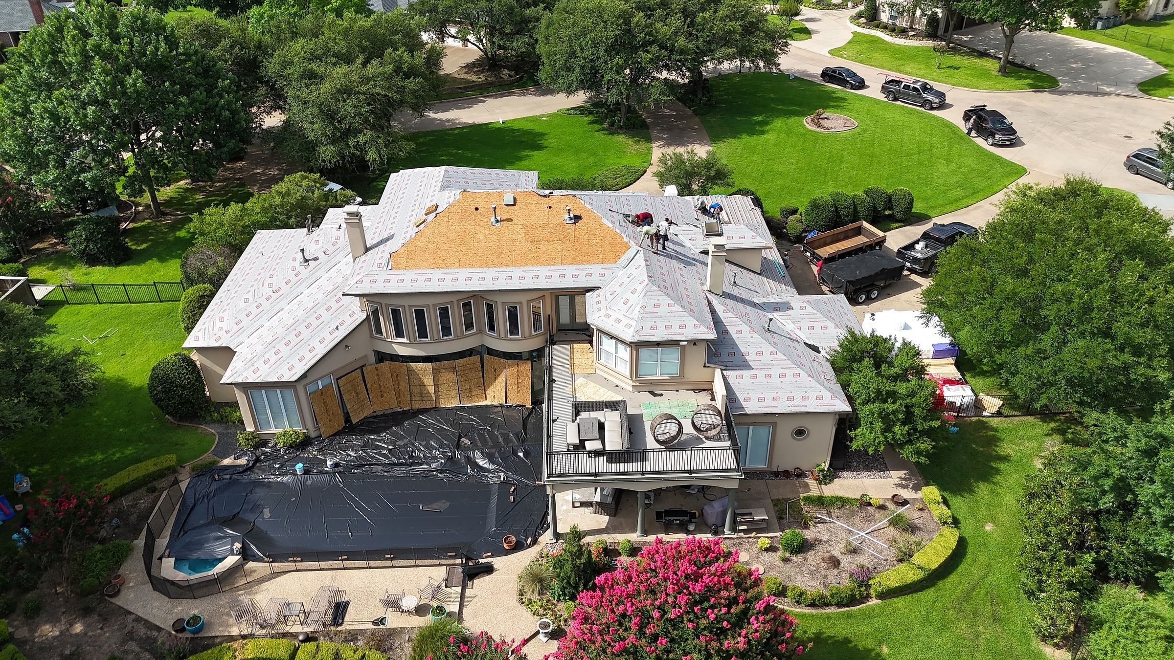 Stucco home in Mansfield, TX dried in with underlayment for a stone-coated steel roof, pool covered