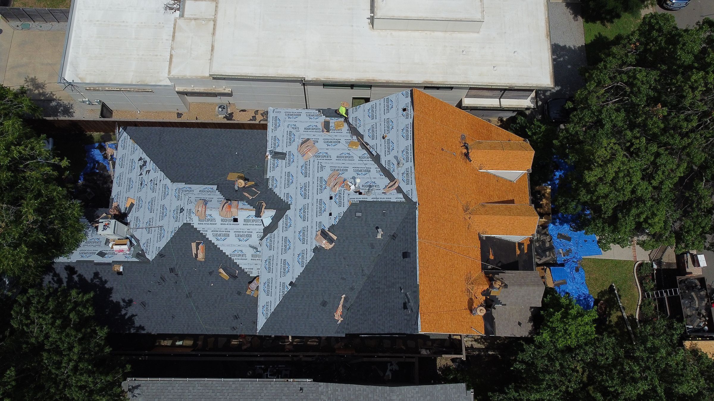 Roof with old shingles, new underlayment and bare decking side by side