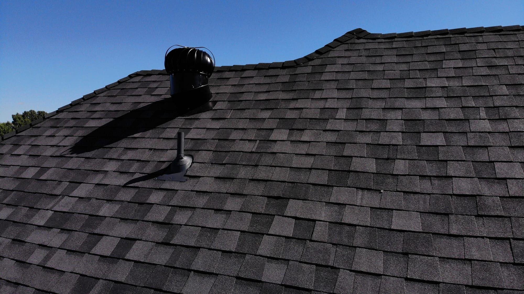 New architectural shingles around a turbine attic vent