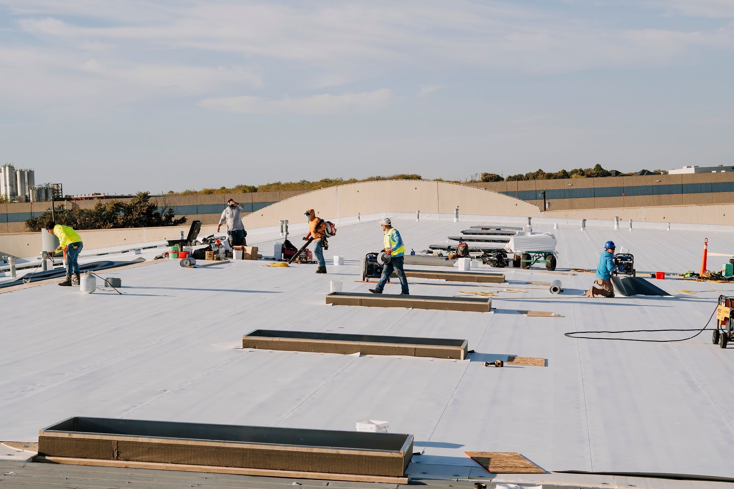 Insulation board laid over the metal panels of a warehouse roof
