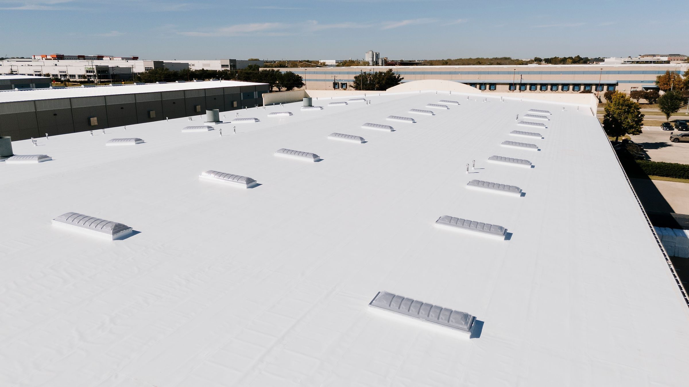 Long view down a finished white TPO warehouse roof