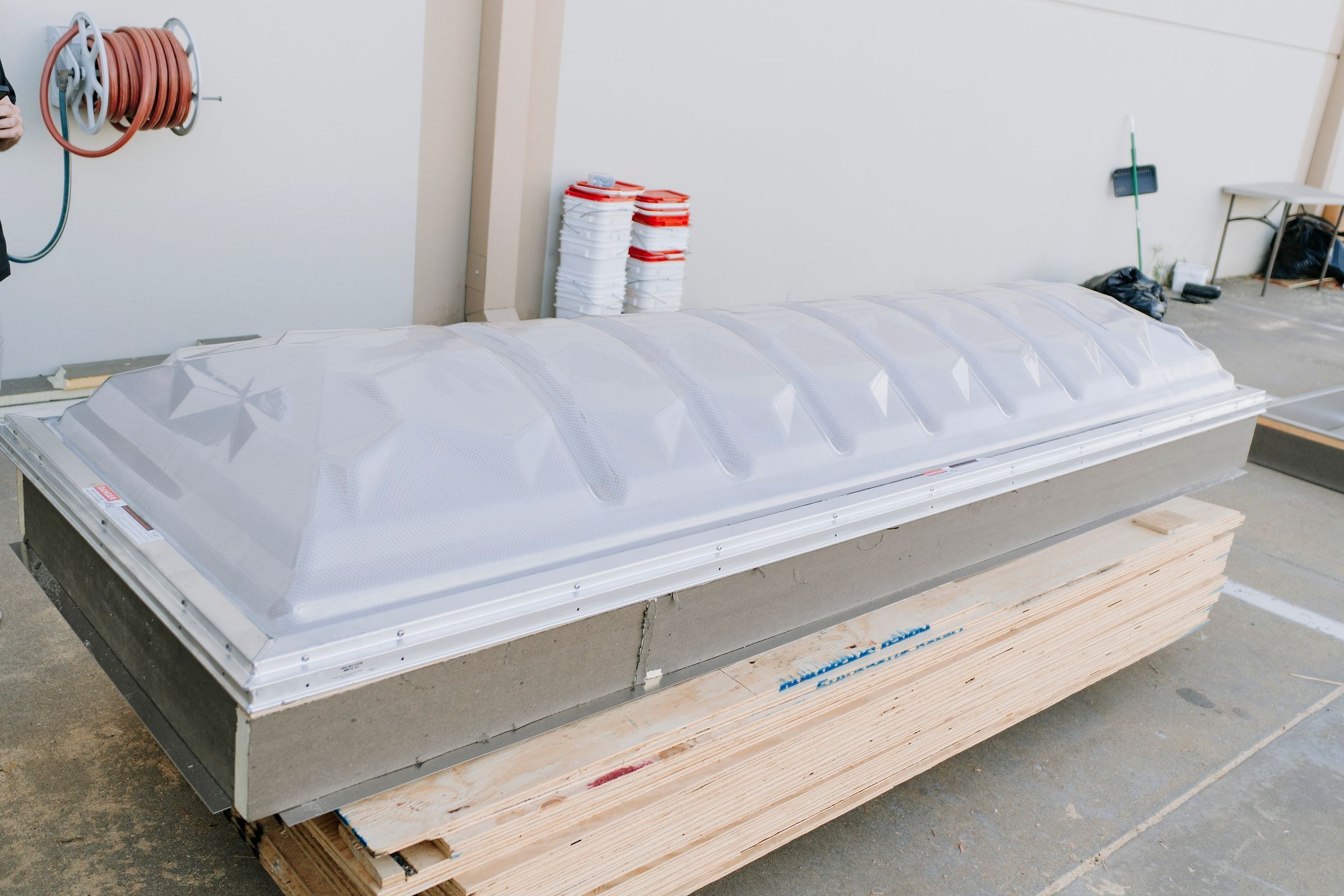 Skylight dome test-fitted on an insulated aluminum curb inside a warehouse